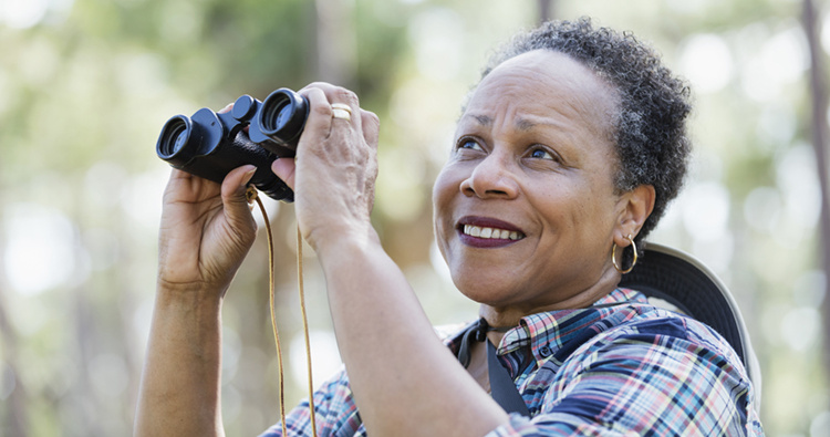 Senior woman with binoculars birdwatching