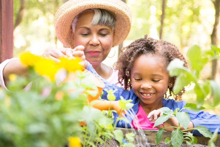 Grandmother-teaching-granddaughter-gardening