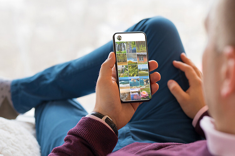 Senior man relaxed looking groups of photos on a phone