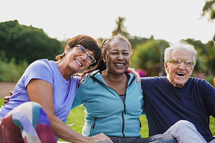 Three seniors laughing and exercising together for brain health