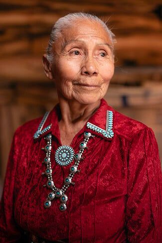 Elderly Indigenous woman in red ceremonial dress