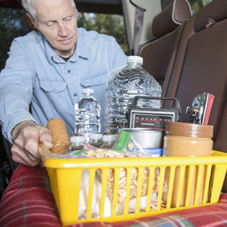 Senior Man with Emergency Kit Supplies in a Car