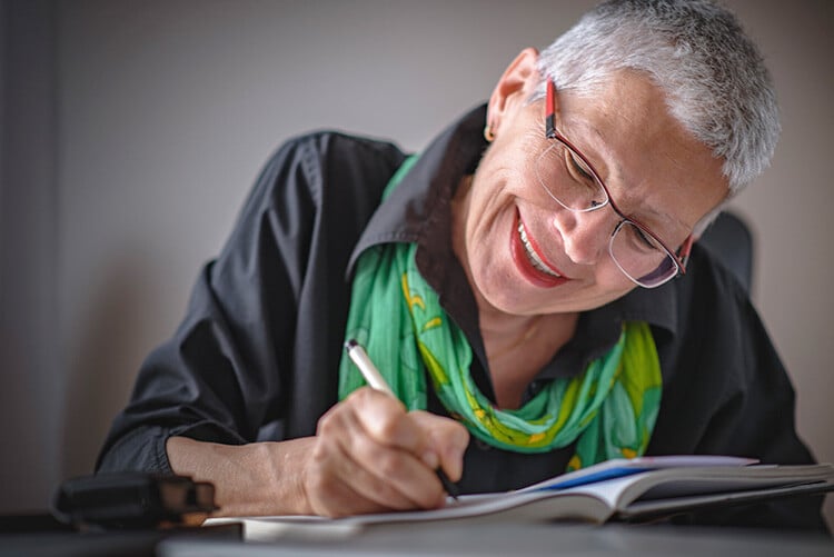 Senior woman writing in gratitude journal