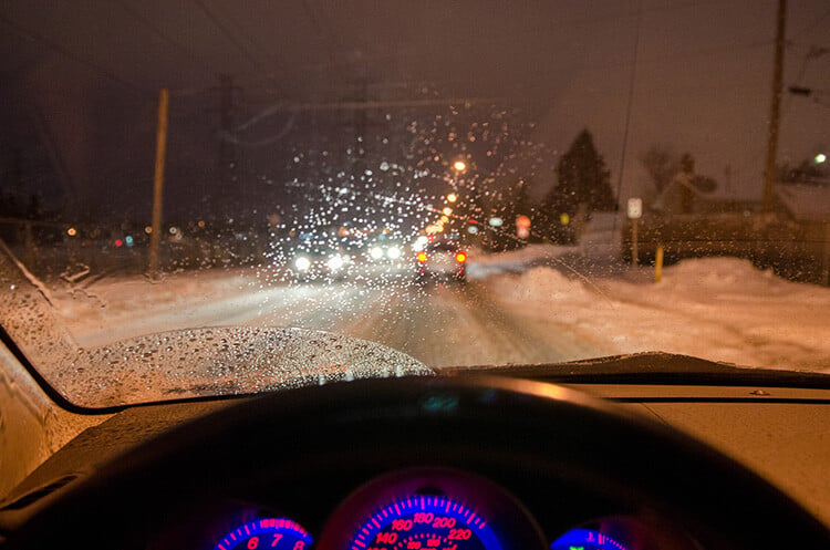 Winter weather driving conditions with blurry windshield during holiday travel