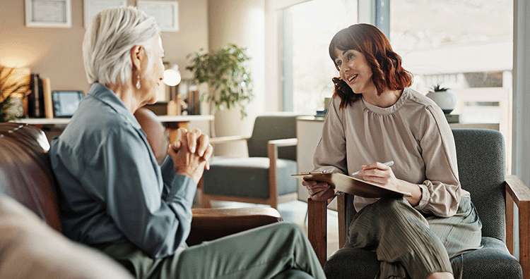 Younger female social working talking to an older adult